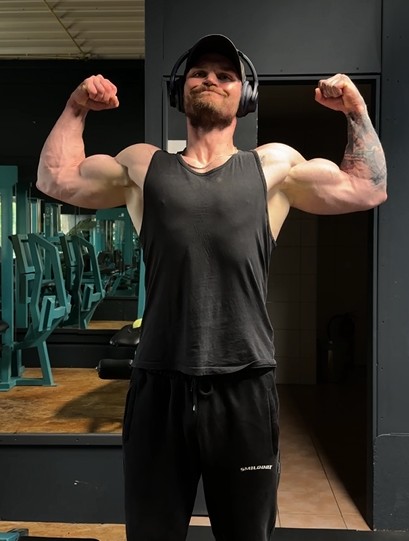 Walter im September 2026 im Gym, beide Arme angespannt